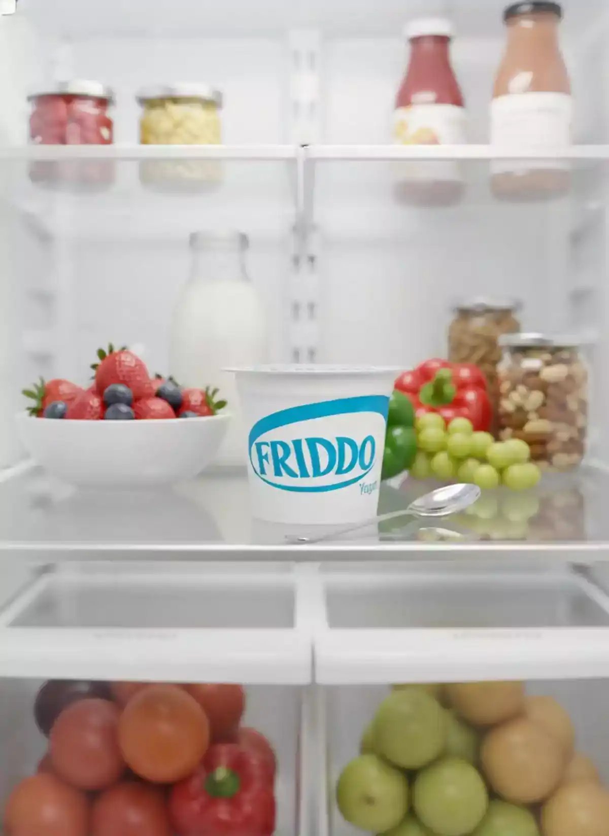A person reaches into a refrigerator filled with fresh fruits, vegetables, and yogurt, then picks up a container of Friddo yogurt in a hyperrealistic photo style suitable for AI product placement and digital art creation.
